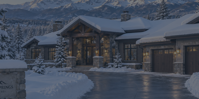 A beautifully snow-covered Pagosa Springs luxury home featuring a freshly plowed driveway and clear winter access.